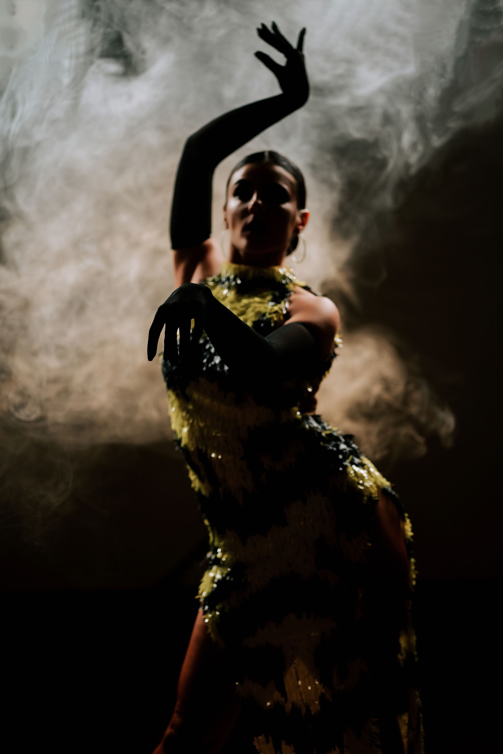 Sensual Latina dancer performs in smoky atmosphere with dramatic lighting